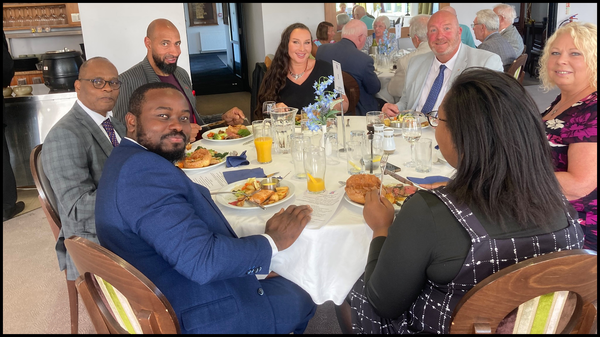 Men and women sat around a round dinning table.